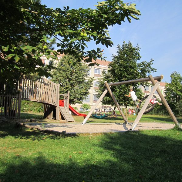 Im Garten befindet sich ein kleiner Spielplatz mit Schaukel, Kletterturm und Rutsche.