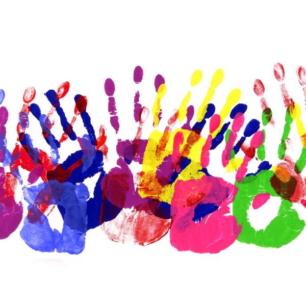 Bunte Farbabdrücke von Händen auf weißem Papier.