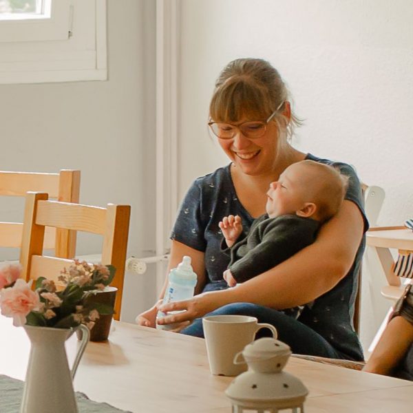 Mütter und ihre Kinder sitzen am Tisch und lachen
