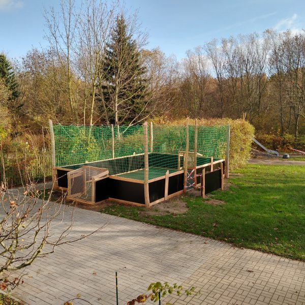 Im Garten des Kindergartens steht ein Fußballfeld mit Banden.