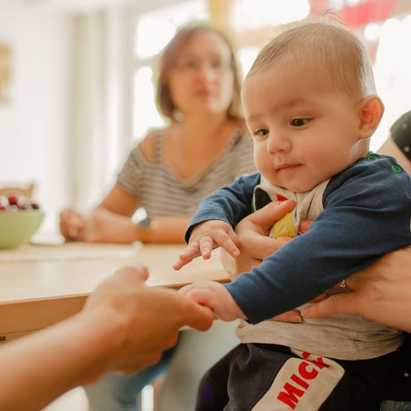 Ein Baby greift die Hand einer Frau