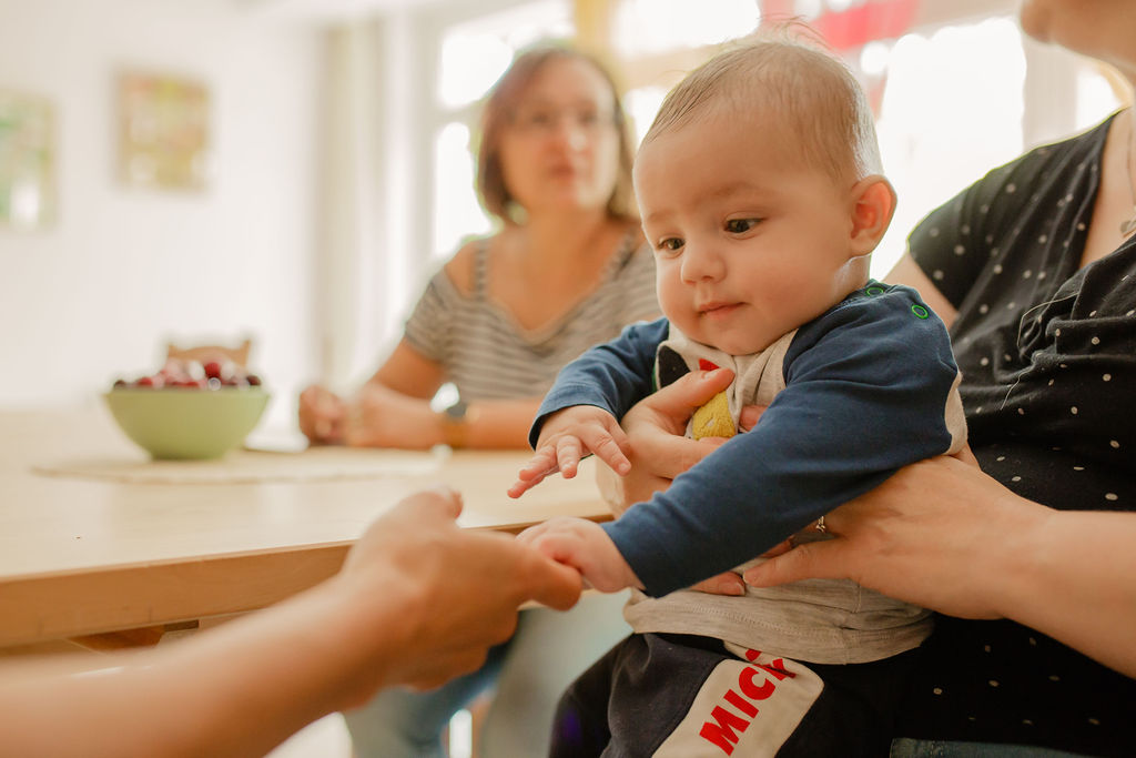 Ein Baby greift die Hand einer Frau