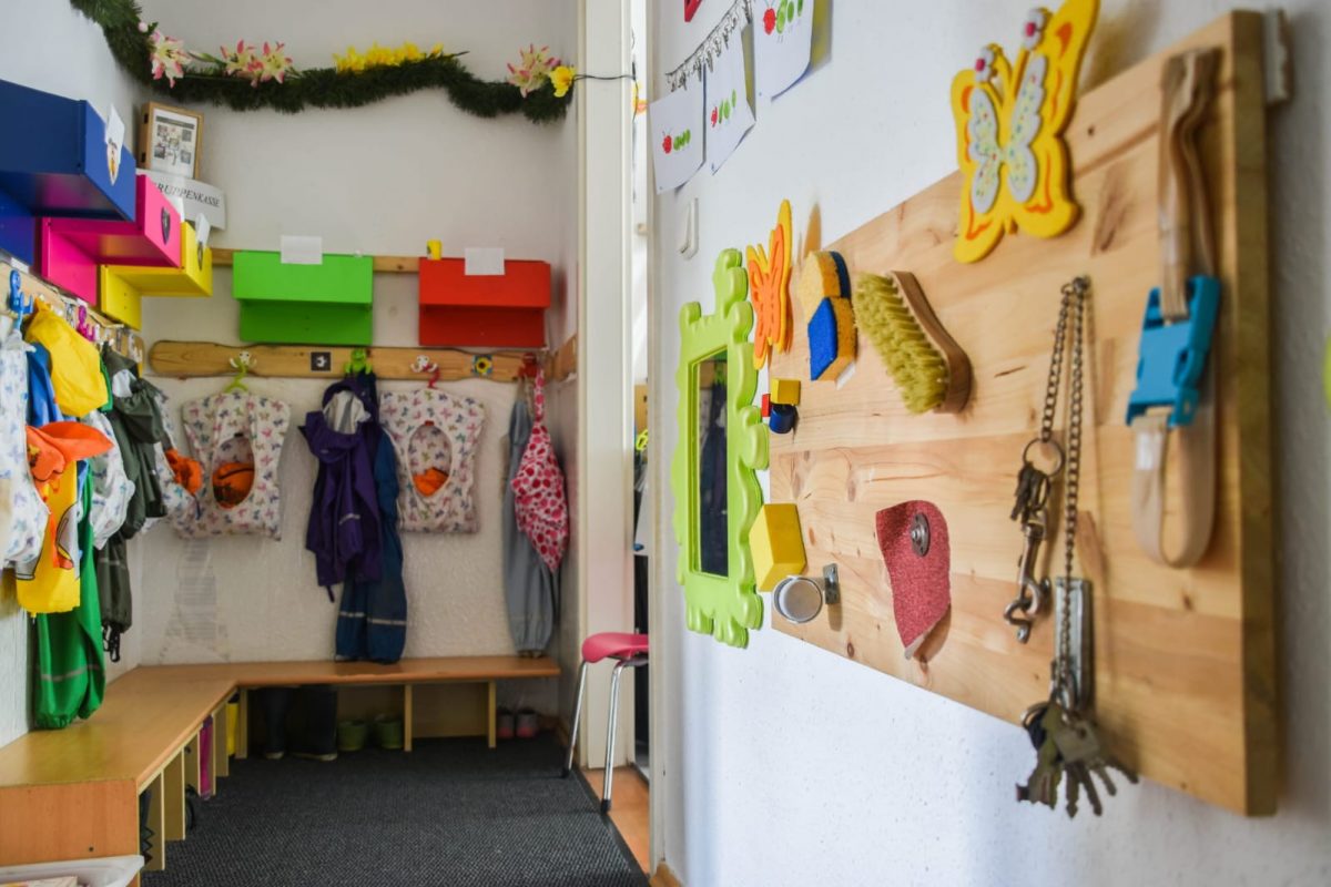 Kindergarderobe und viele Activity-Boards an der Wand.