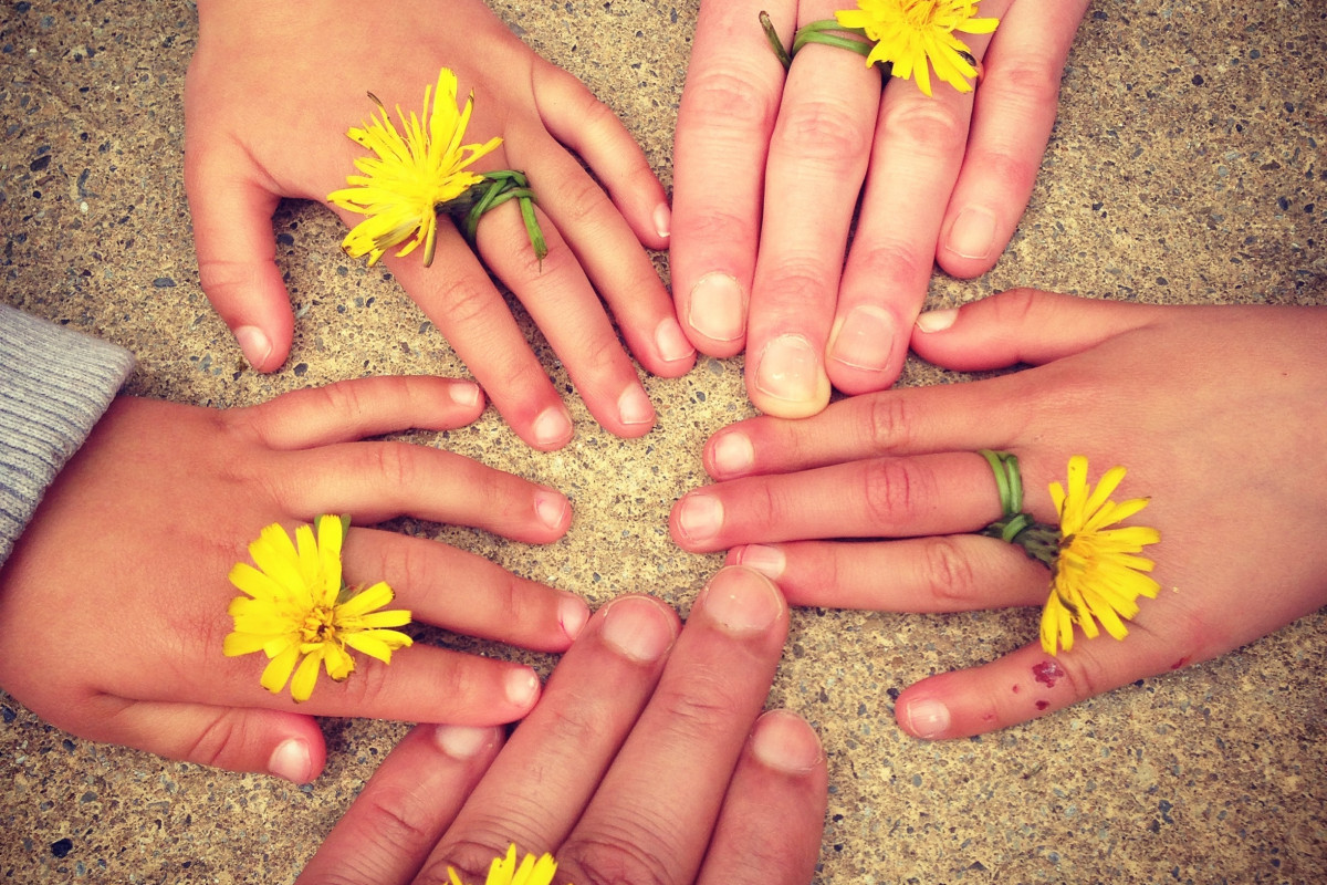 Hände von Kindern und Erwachsenen im Kreis angeordnet