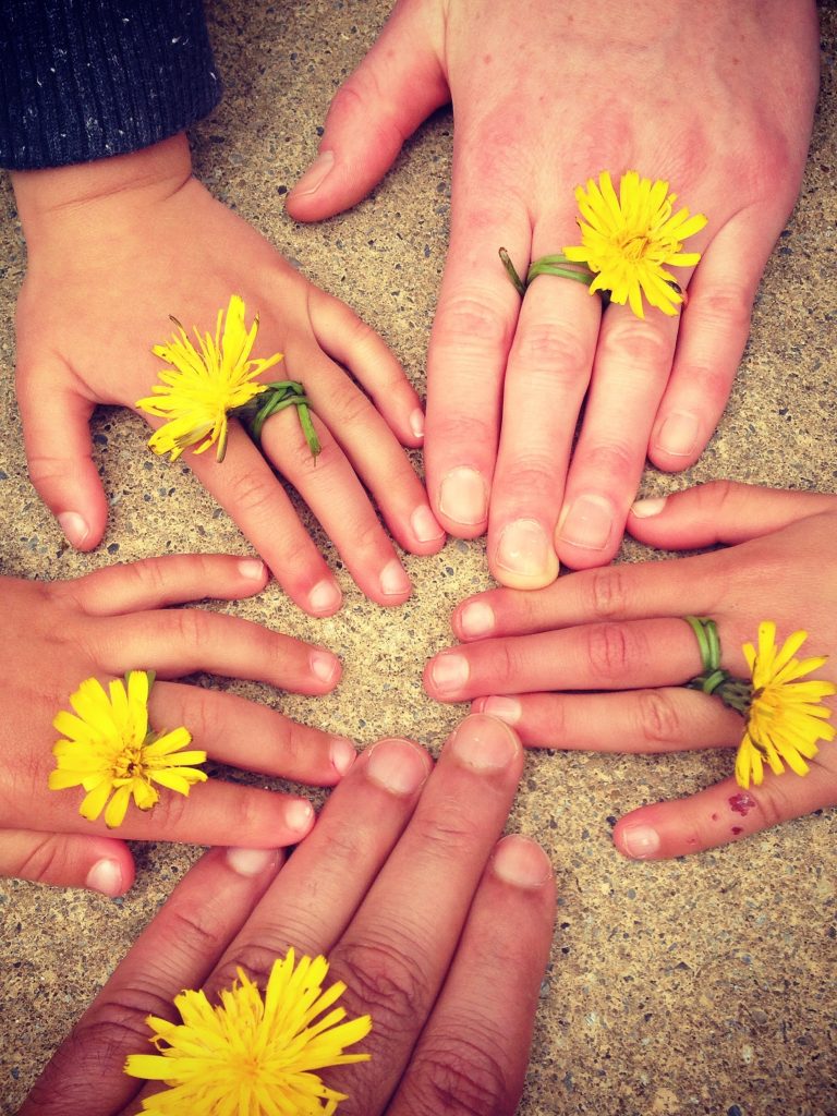 Hände von Kindern und Erwachsenen im Kreis angeordnet