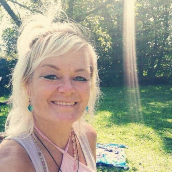 Ein Bild einer lächelnden Frau, die sich ein einem Park aufhält.