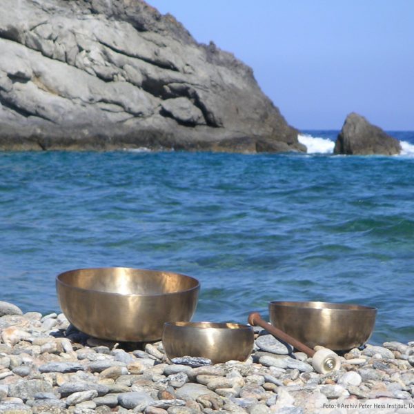 Klangschalen an Steinstrand vor Meer