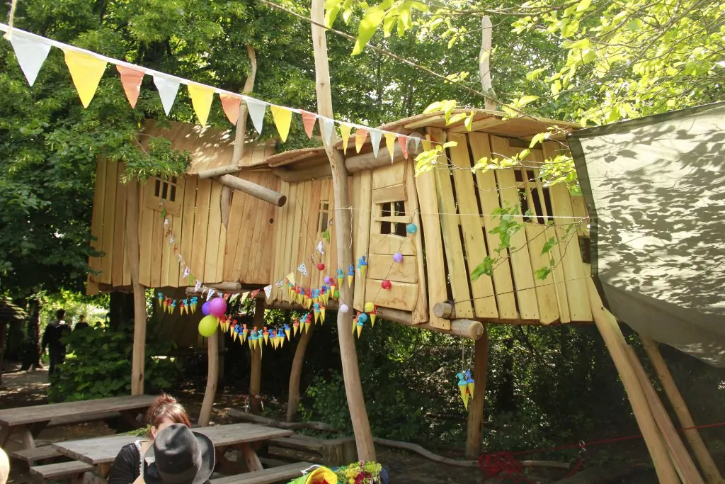 Ein Kinder-Baumhaus, geschmückt mit bunten Wimpelketten