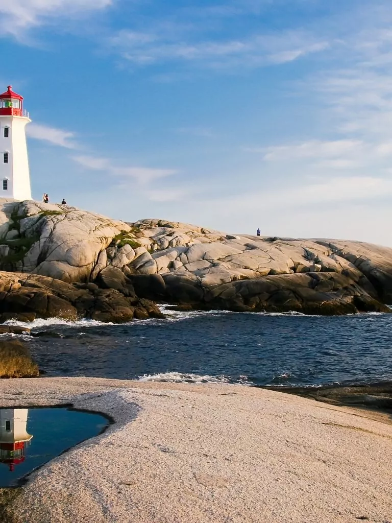 Ein Leuchtturm auf einem Fels-Vorsprung, der ins Meer hineinragt