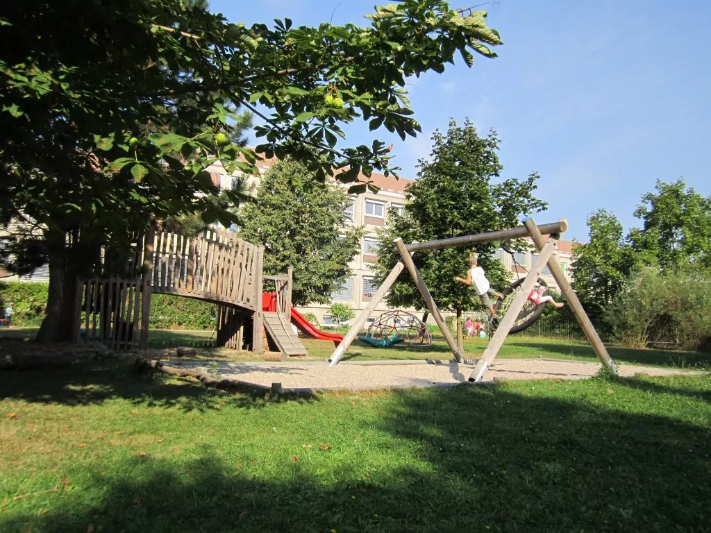 Im Garten befindet sich ein kleiner Spielplatz mit Schaukel, Kletterturm und Rutsche.