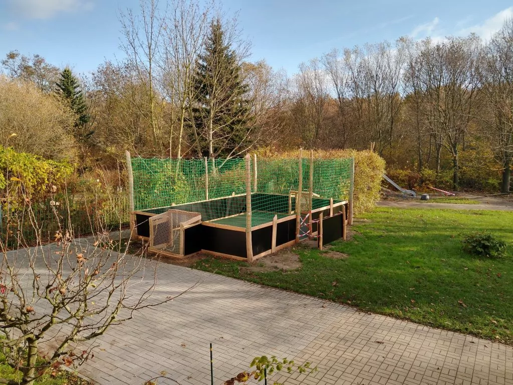 Im Garten des Kindergartens steht ein Fußballfeld mit Banden.