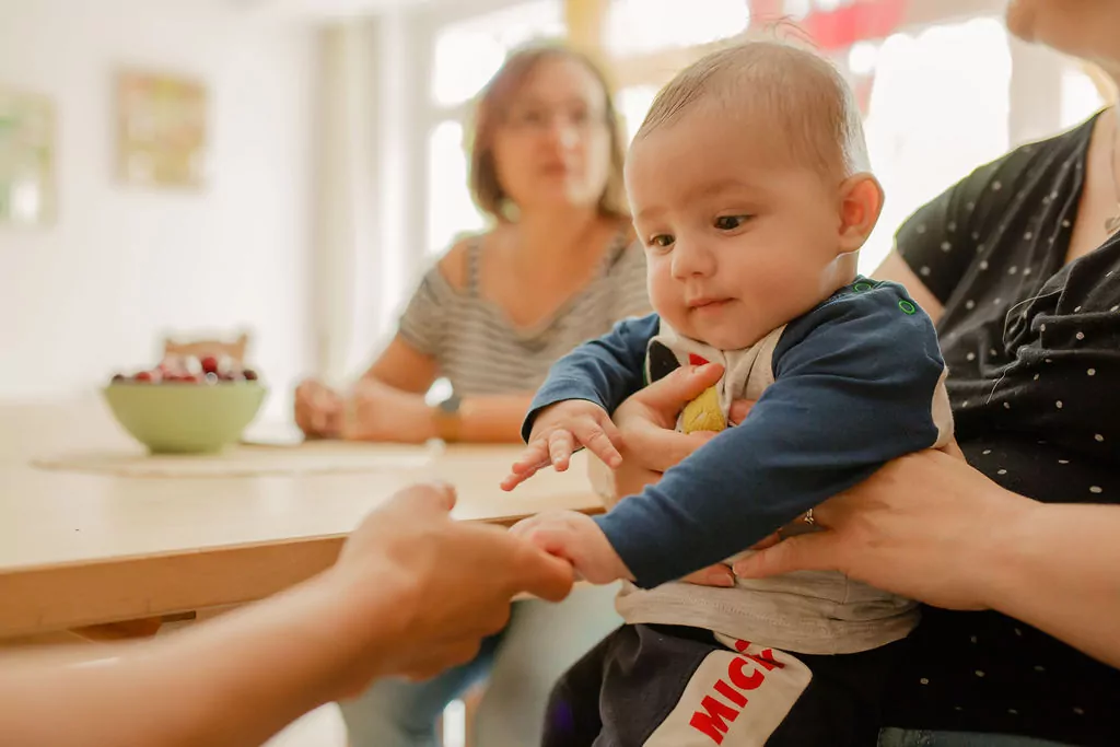 Ein Baby greift die Hand einer Frau