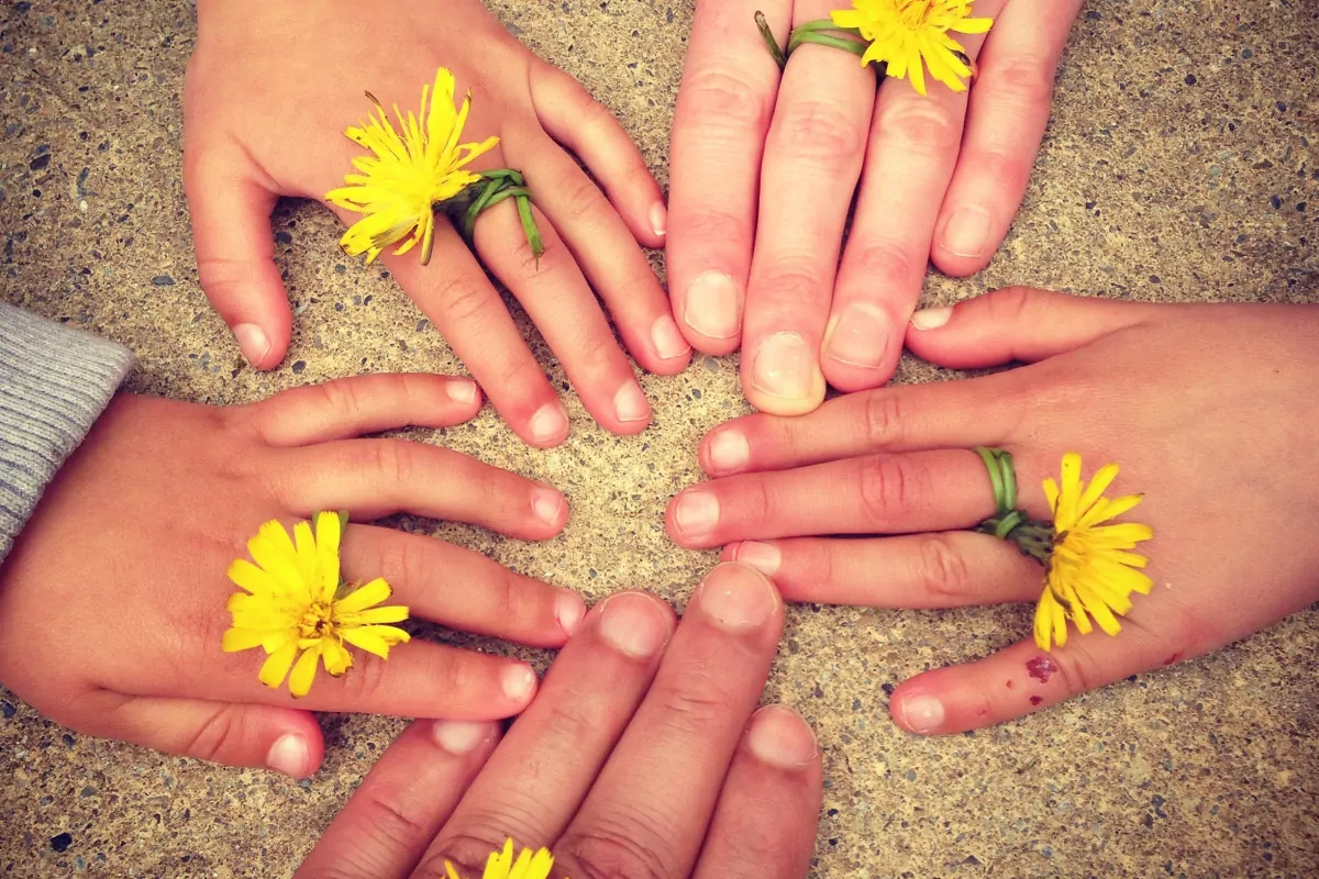 Hände von Kindern und Erwachsenen im Kreis angeordnet