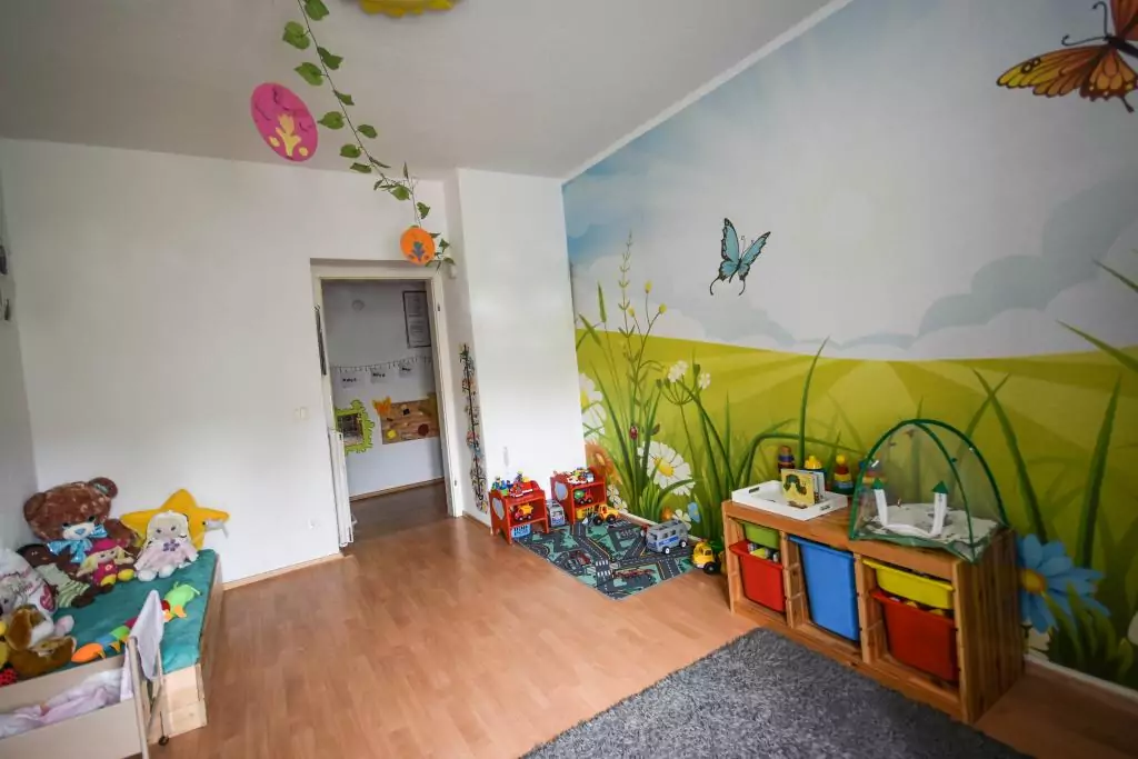 Buntes Kinderzimmer mit Spielzeug und Kuschelecke.