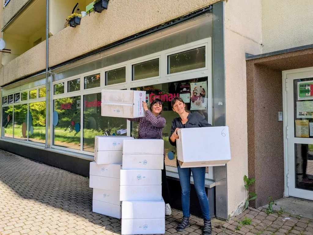 Cindy Deckert und Stephanie Schmutzer stapeln Umzugskartons vor dem Grünauer Familienzentrum.