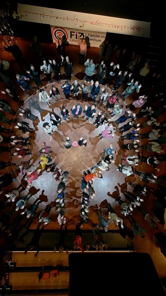 Freunde und Mitarbeitende des FiZ Leipzig stellen gemeinsam die Konturen des neuen Vereinslogos Leipzig nach.